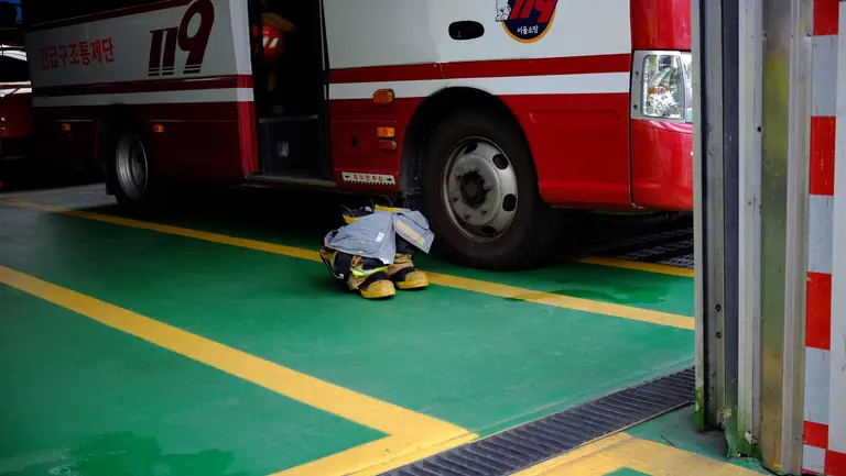 Firefighter gear placed near an emergency vehicle at a fire station in Seoul, South Korea.