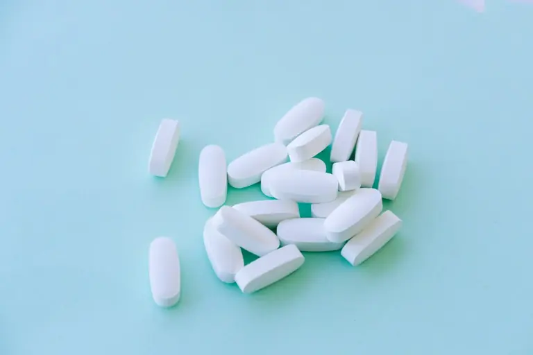 A pile of pills sitting on top of a blue table