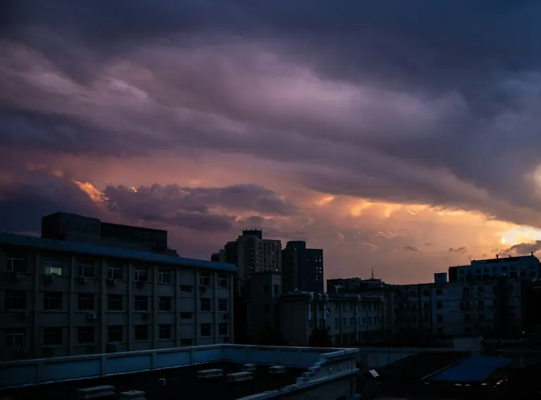 city buildings under orange and gray cloudy sky during sunset
