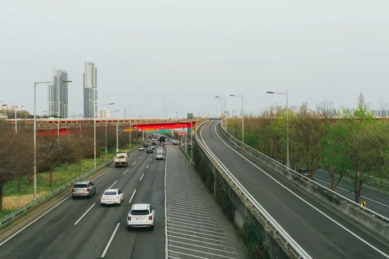 An urban highway in Seoul, South Korea, amidst a modern skyline during spring.