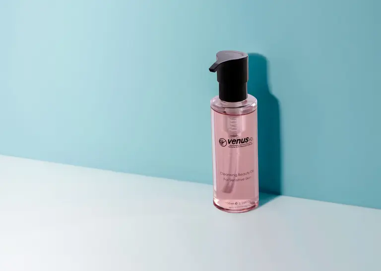 Pink cleansing oil bottle on a minimalist background, ideal for skincare and beauty themes.